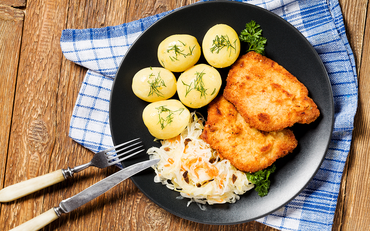 Chuleta de cerdo empanada con patatas y coleslaw