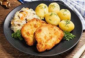 Chuleta de cerdo empanada con patatas y coleslaw Chuleta de cerdo empanada con patatas y coleslaw