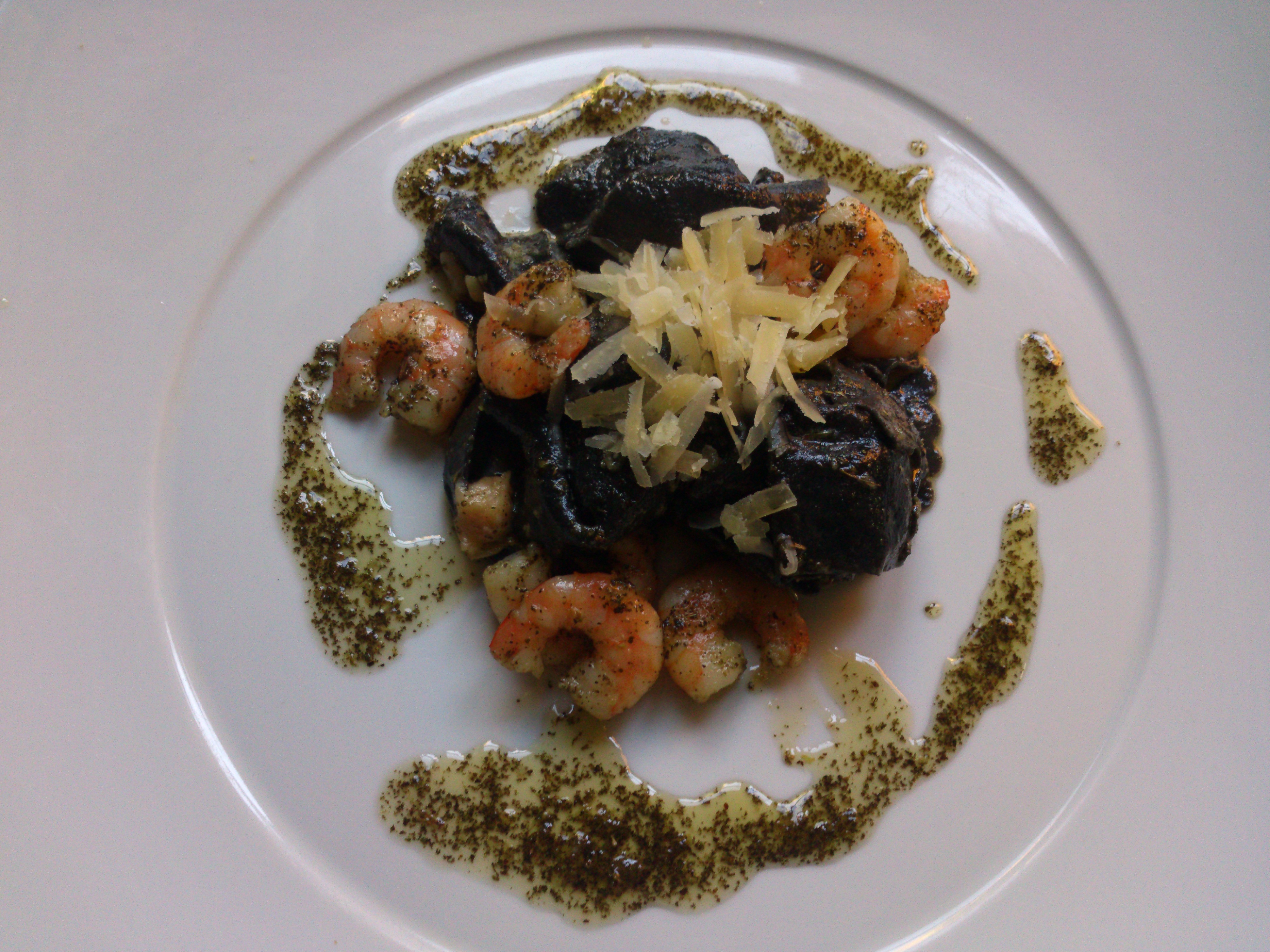 Tortellini de tinta de sepia rellenos de salmón ,con salsa pesto y gambas