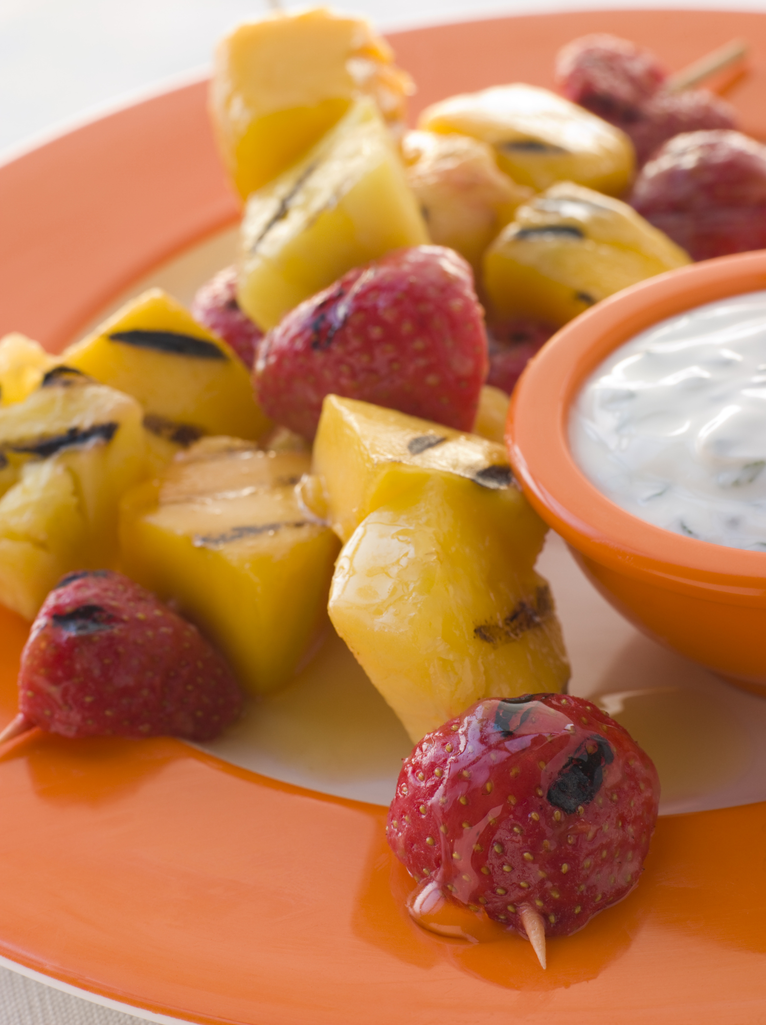 Brochetas de frutas caramelizadas con crema inglesa