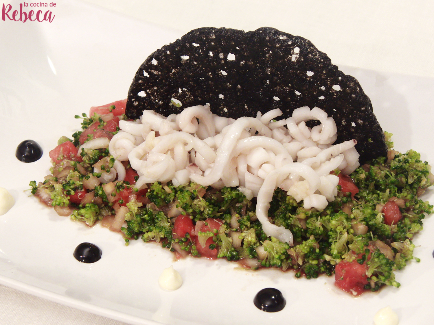 Cous cous de brócoli con calamares enrollados y crujiente de su tinta