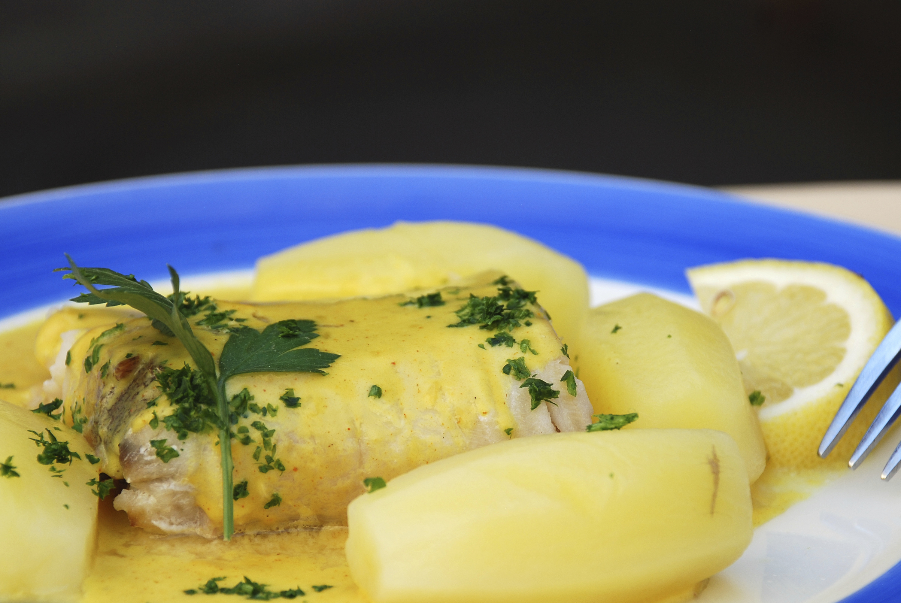 Merluza con patatas, cebolla y salsa de naranja