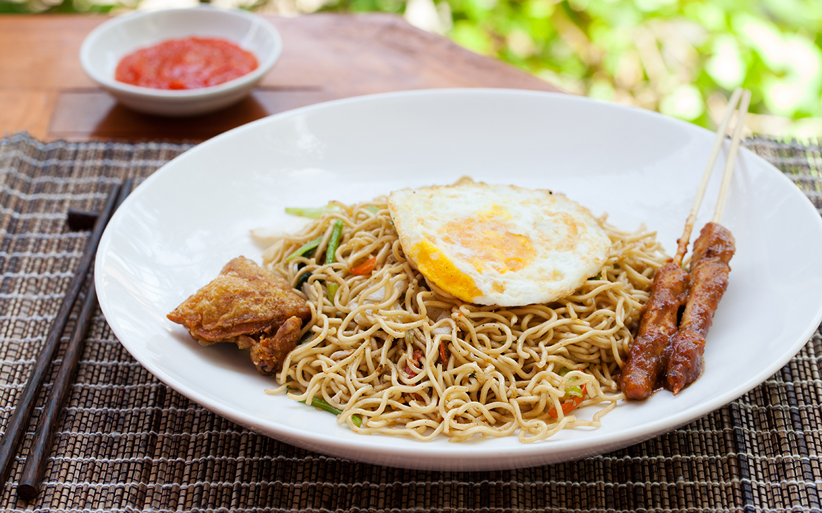 Noodles fritos con huevo y brocheta de cerdo