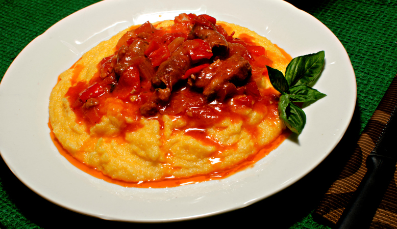 Polenta con queso y salchichas en salsa de tomate