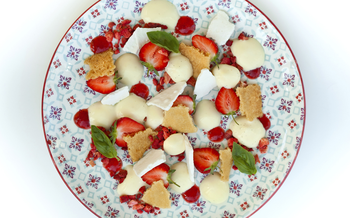 Postre de fresitas, galleta, merengue, frutos deshidratados y crema