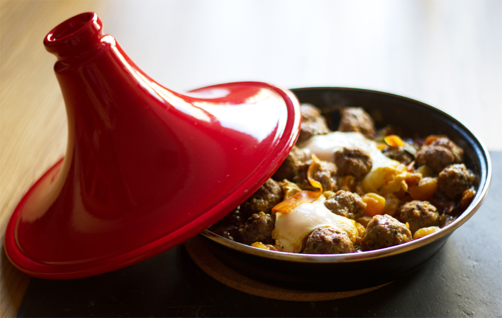 Tajine de jugosas albóndigas sobre cama de verduras