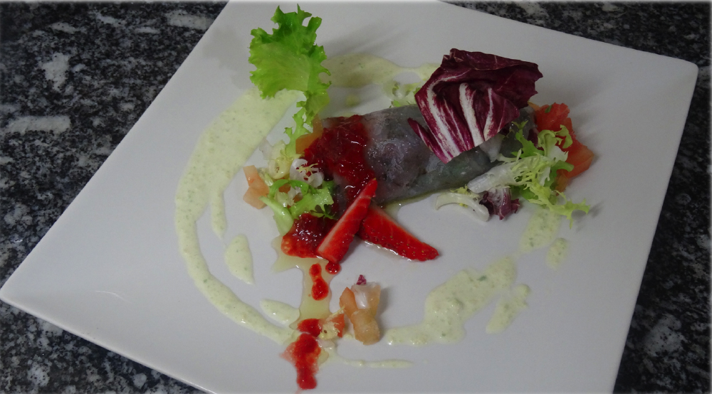 Rulo de carpaccio de langostinos relleno de ensalada con toques primaverales y cítricos.